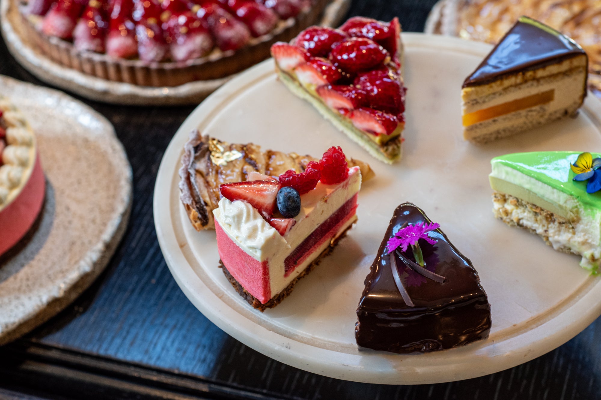 Assorted slices of cake on a plate from Belle Époque at Emporium Hotel